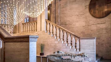 A staircase with a wooden handrail and a large crocodile sculpture in the foreground.