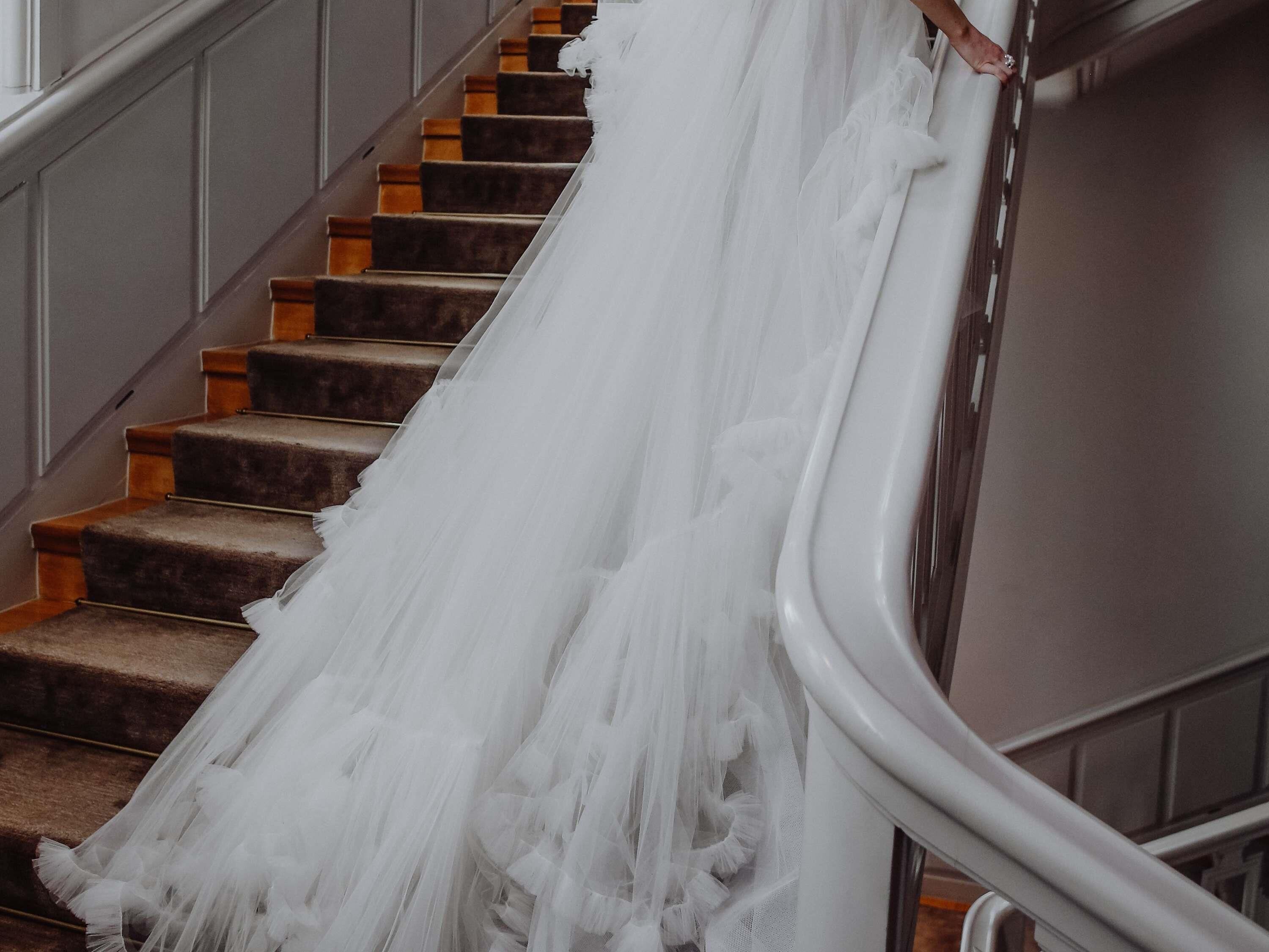 Un escalier sur lequel est drapée une robe de mariée blanche.