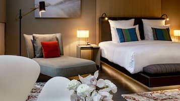 Een hotelkamer met een bed, een stoel, een bureau, een vaas met bloemen en een tijdschrift.