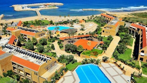 Un resort con varias piscinas, una playa y vista al océano.