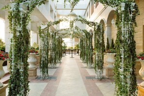 An indoor corridor with arches and columns, decorated with greenery and potted plants. - The Langham, Shenzhen (Shenzhen)