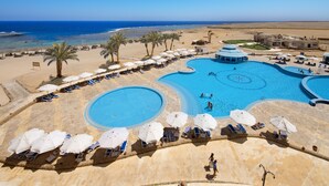 A resort with a large pool, sun loungers, umbrellas, and a view of the beach and ocean. - Concorde Moreen Beach Resort & Spa (Marsa Alam)