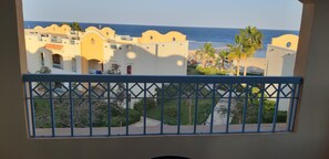 A balcony with a view of a coastal area, featuring buildings with balconies and a beach in the background. - Concorde Moreen Beach Resort & Spa (Marsa Alam)