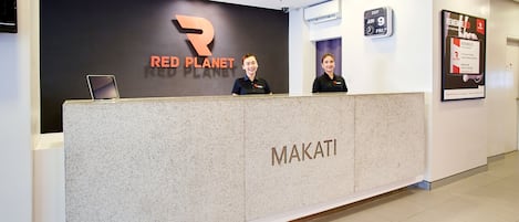 A reception desk with a sign reading "RED PLANET" and a digital clock displaying "2017 JUN 9".