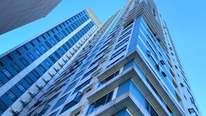 A high-rise building with a modern architectural design, featuring a prominent corner and multiple windows. - One Pacific Place Serviced Residences (Makati)