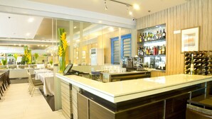 A modern bar area with a long counter, seating, and a wine rack. - One Pacific Place Serviced Residences (Makati)