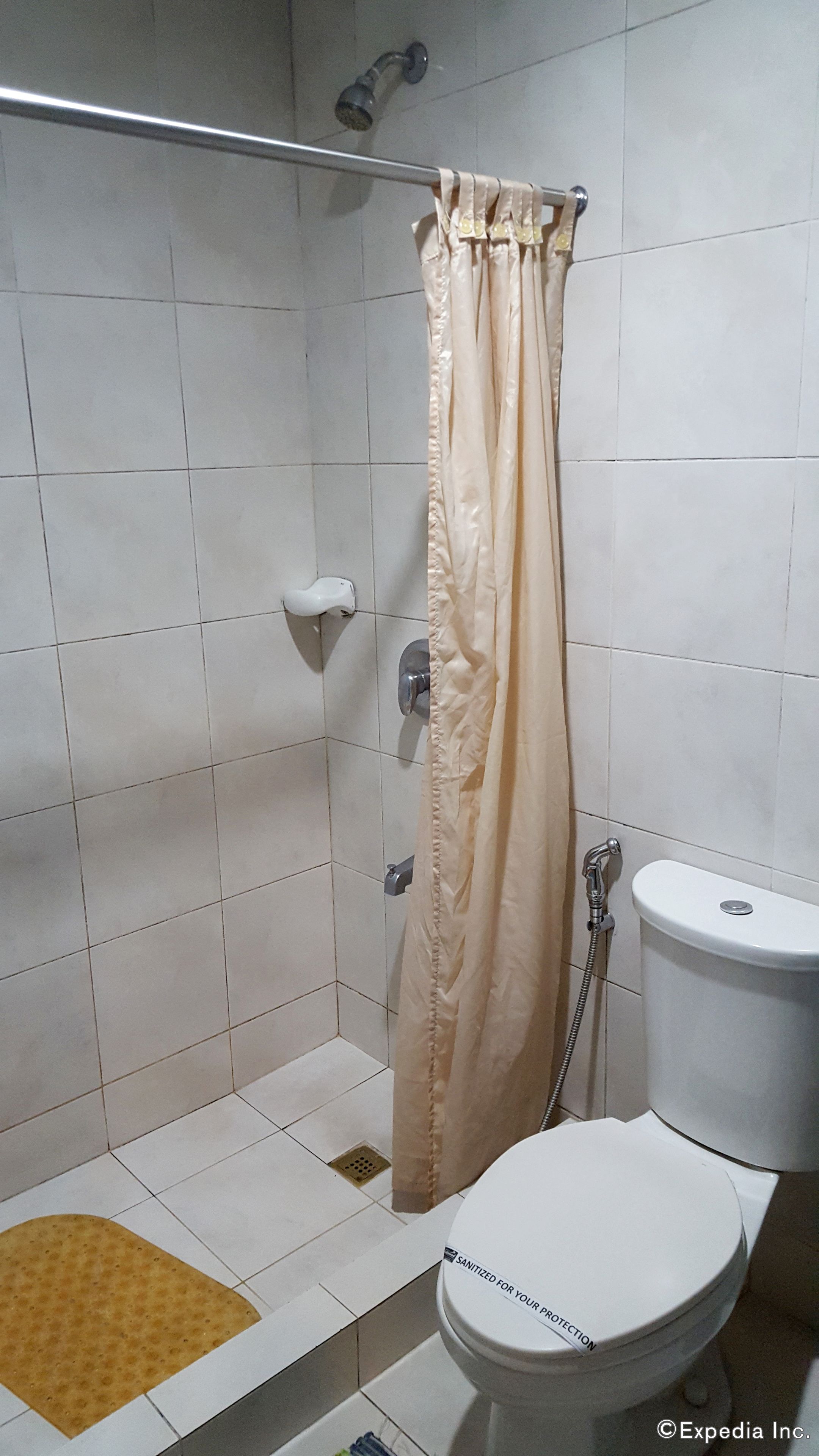 Een douche, pantoffels, een bidet, handdoeken