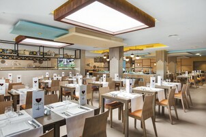 Un restaurante con varias mesas, cada una dispuesta con copas de vino y menús.