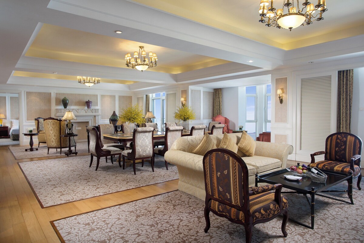 A spacious living area with a dining set, multiple chairs, a sofa, and a coffee table.
