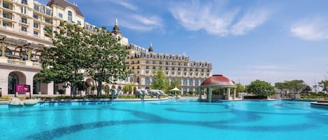 Een groot hotel met een zwembad, meerdere balkons en een prieel.