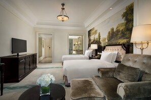 A hotel room with two beds, a sofa, a television, a desk, and a painting on the wall. - Crowne Plaza Qingdao Ocean Spring Resort by IHG (Qingdao)