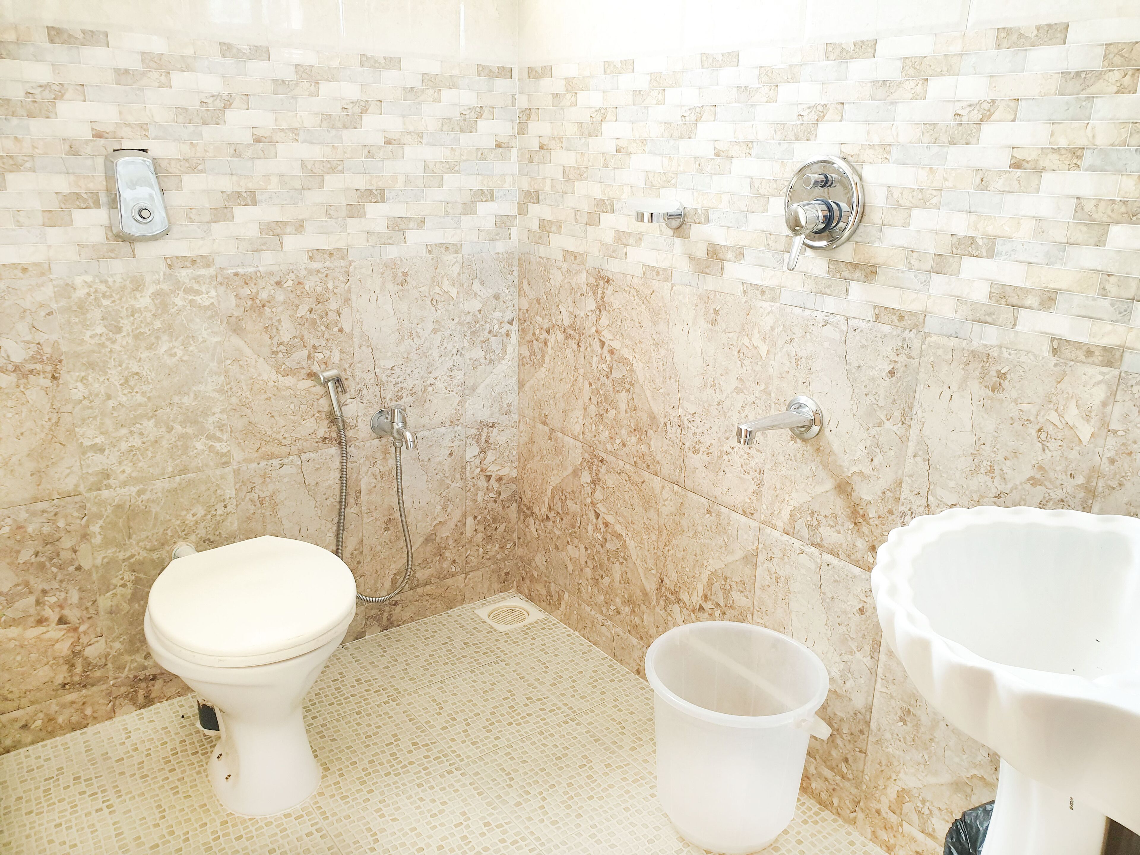 A bathroom with a toilet, a shower, and a sink.