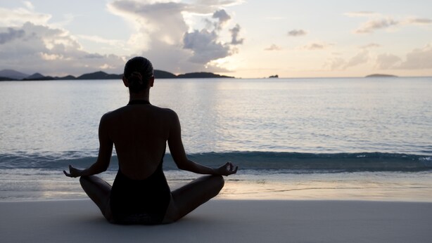 A person meditating on a beach with a view of the ocean and distant islands. - Veronica Guest House (Calangute)