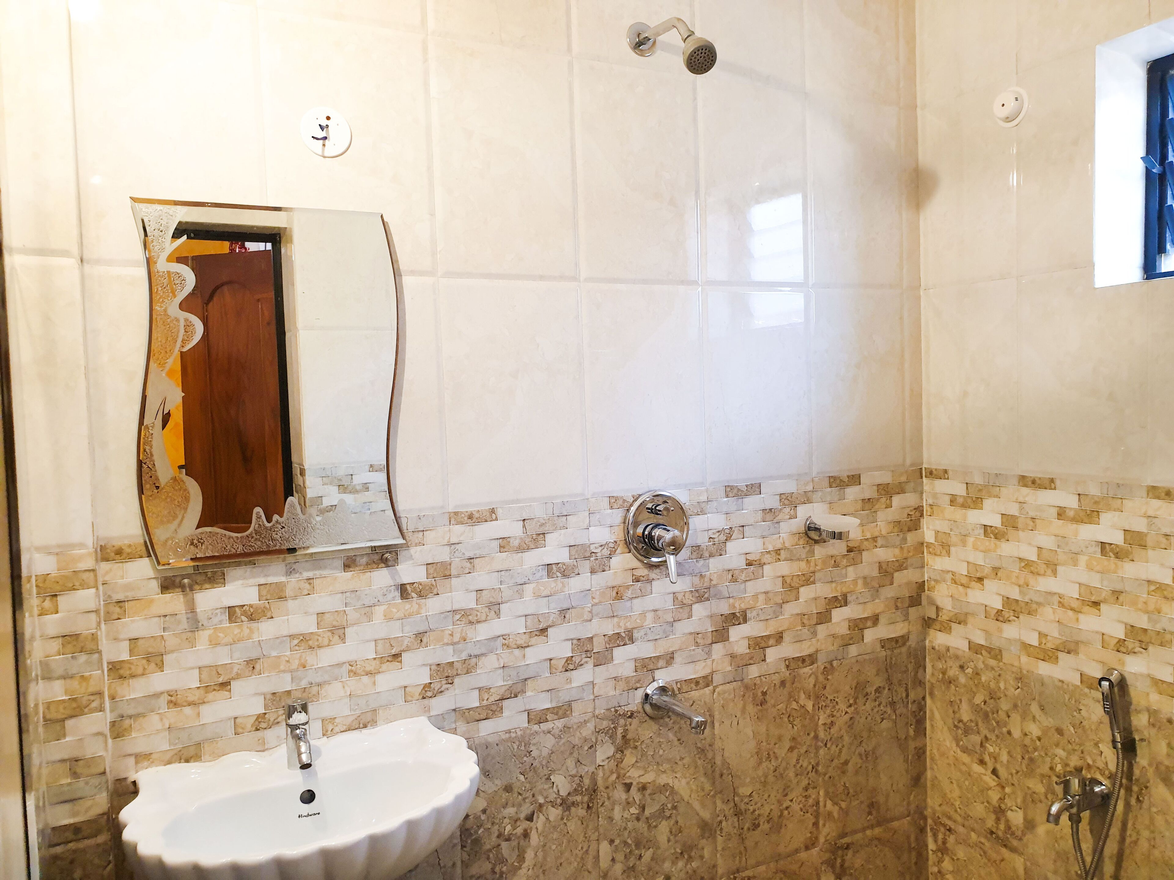Un baño con lavabo, ducha y espejo.