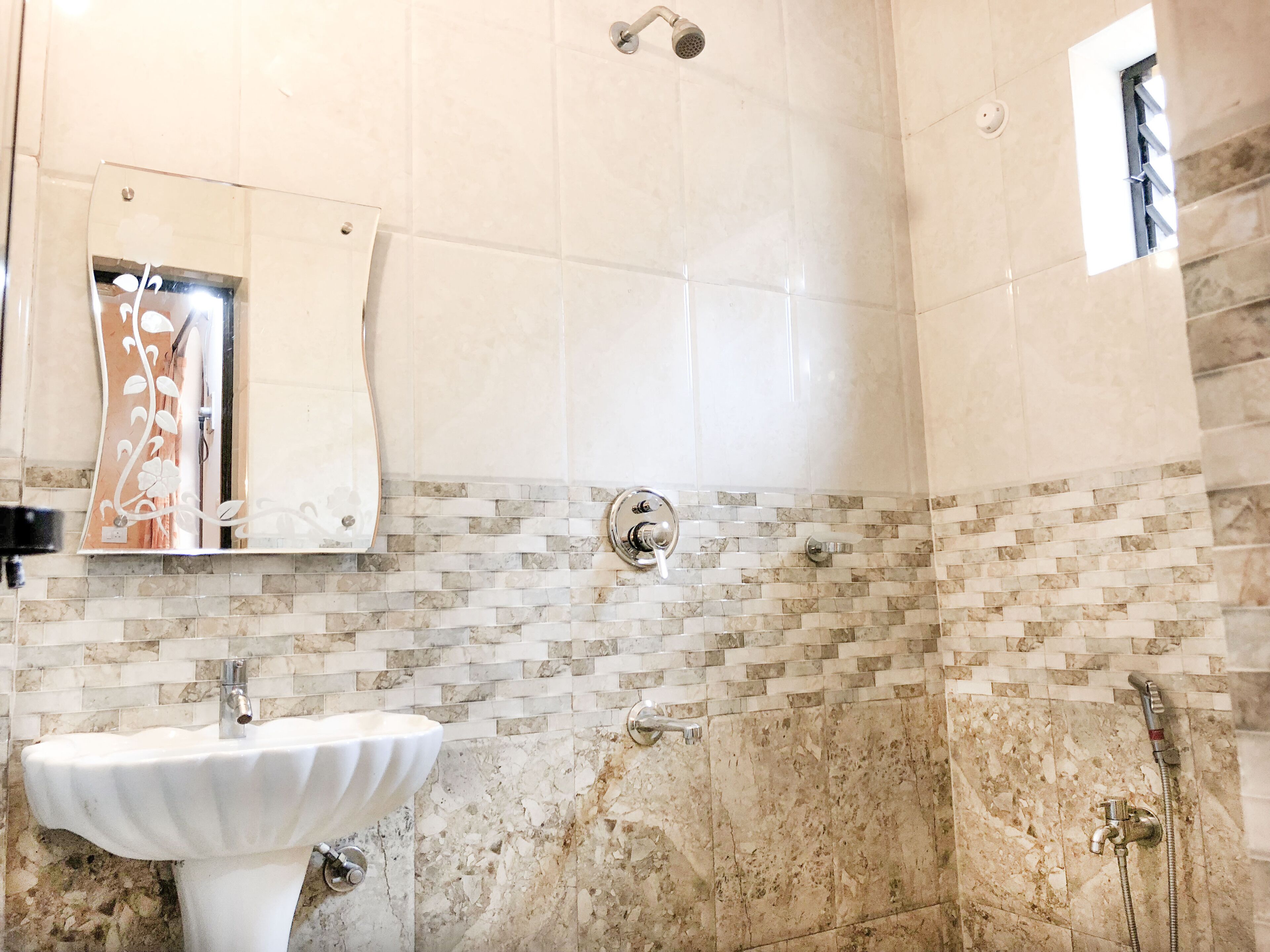 A bathroom with a white sink, a mirror, and a shower.