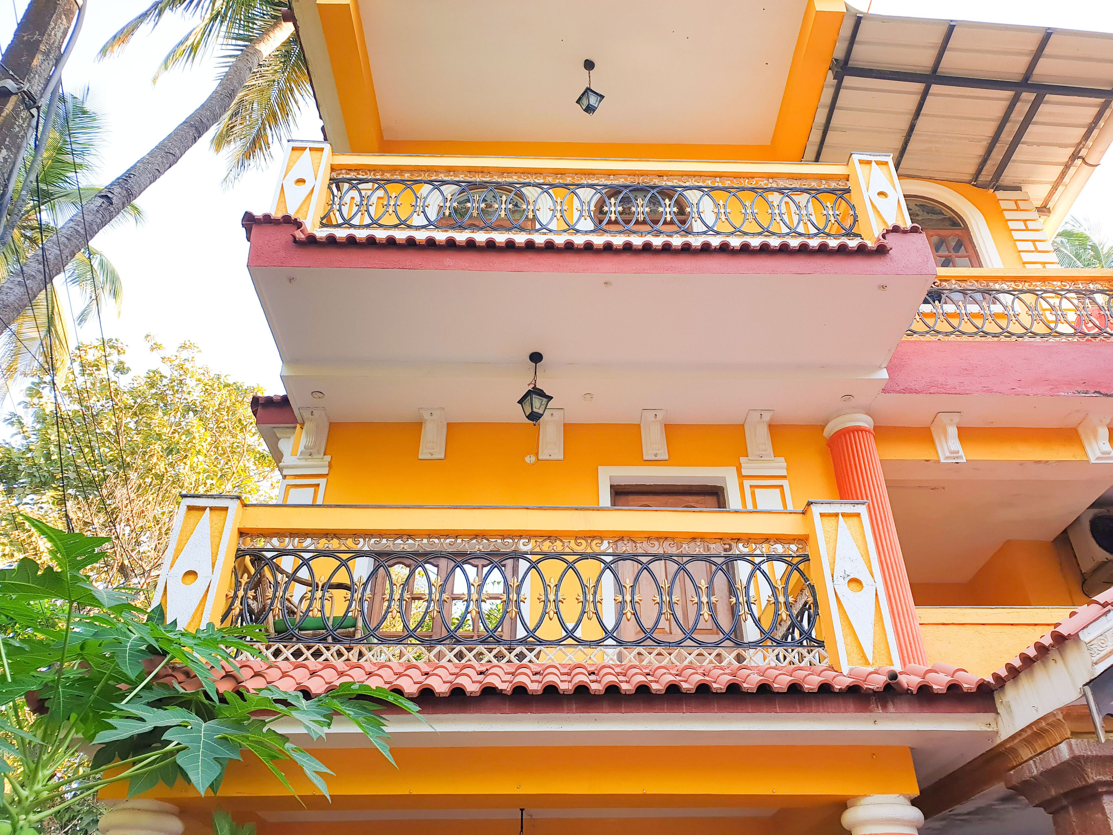 A multi-story building with balconies, a tiled roof, and decorative railings.