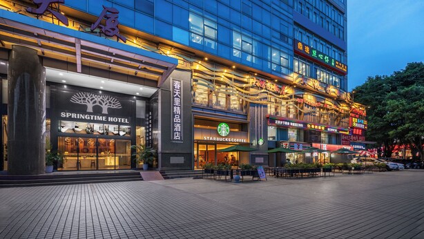 A hotel with a Starbucks Coffee, Springtime Hotel, and various shops on the ground floor. - Spring Time Hotel (Guangzhou)