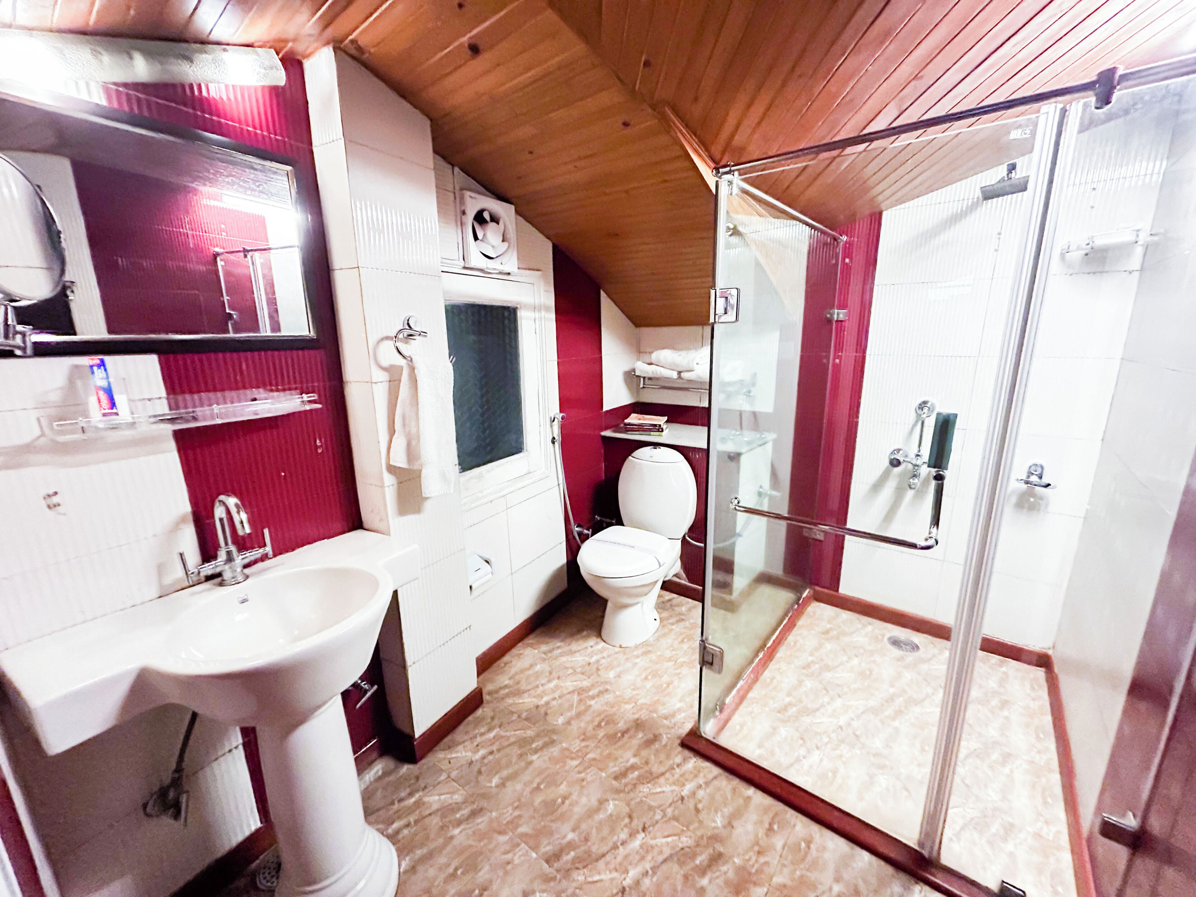 Un baño pequeño con lavamanos, inodoro y ducha con mampara de vidrio.