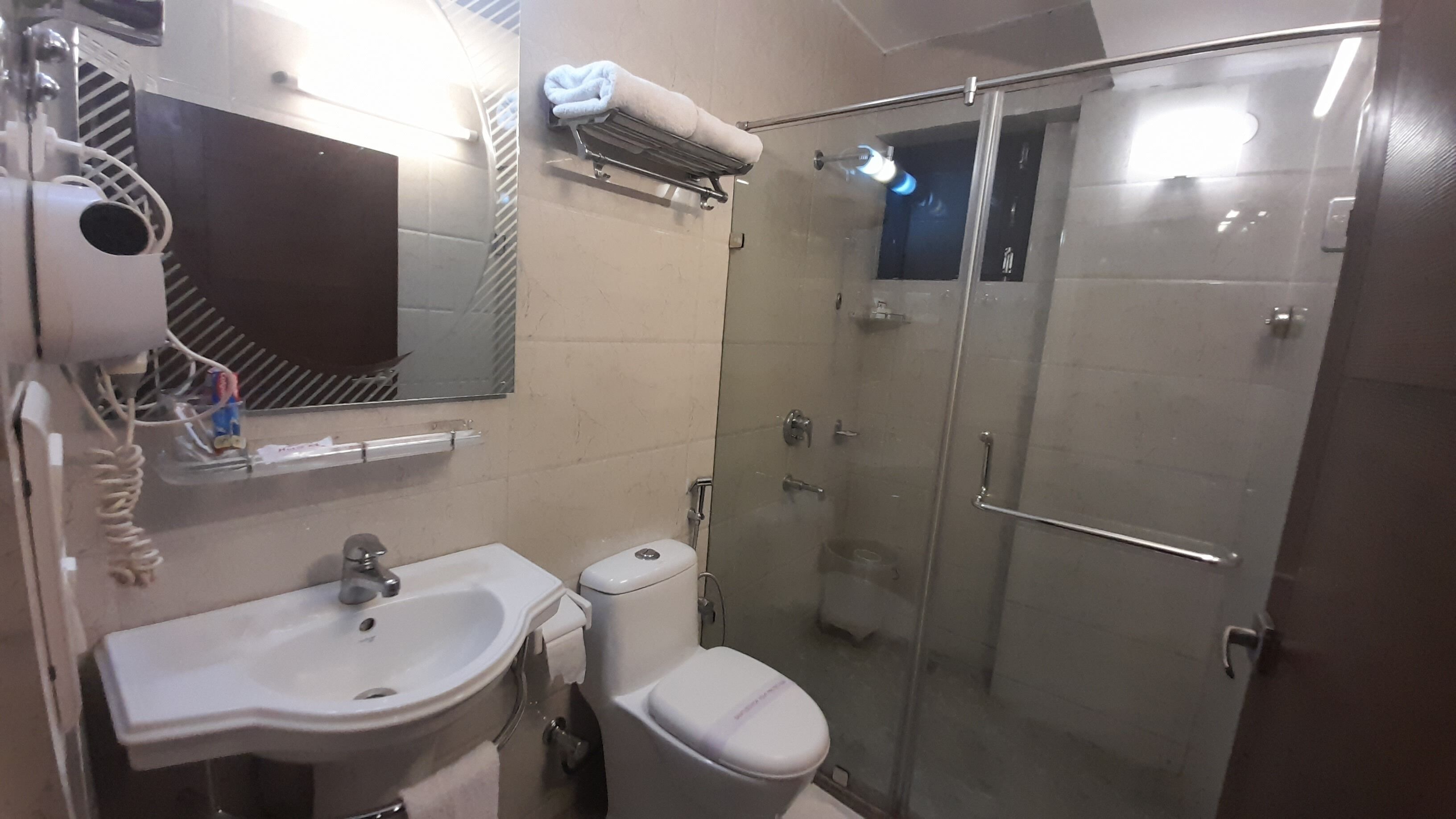 A bathroom with a sink, toilet, and glass-enclosed shower.