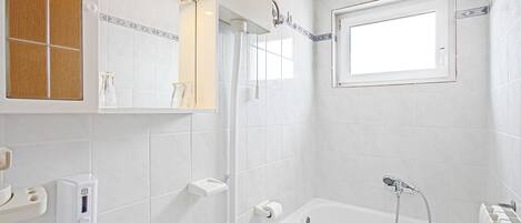 A modern bathroom with a bathtub, a sink, and a mirror.