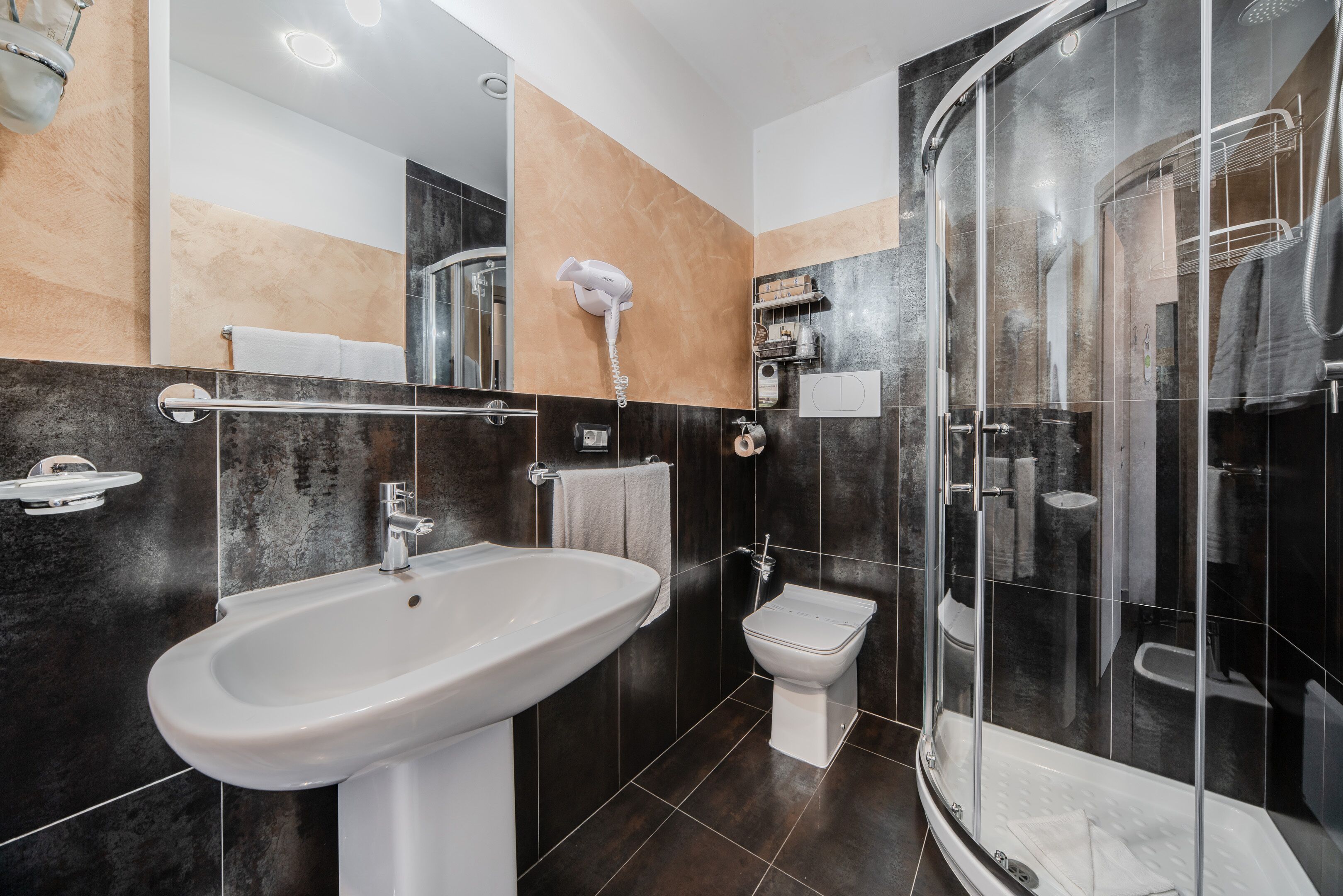 Un bagno moderno con bidet, cabina doccia e mobile lavabo.