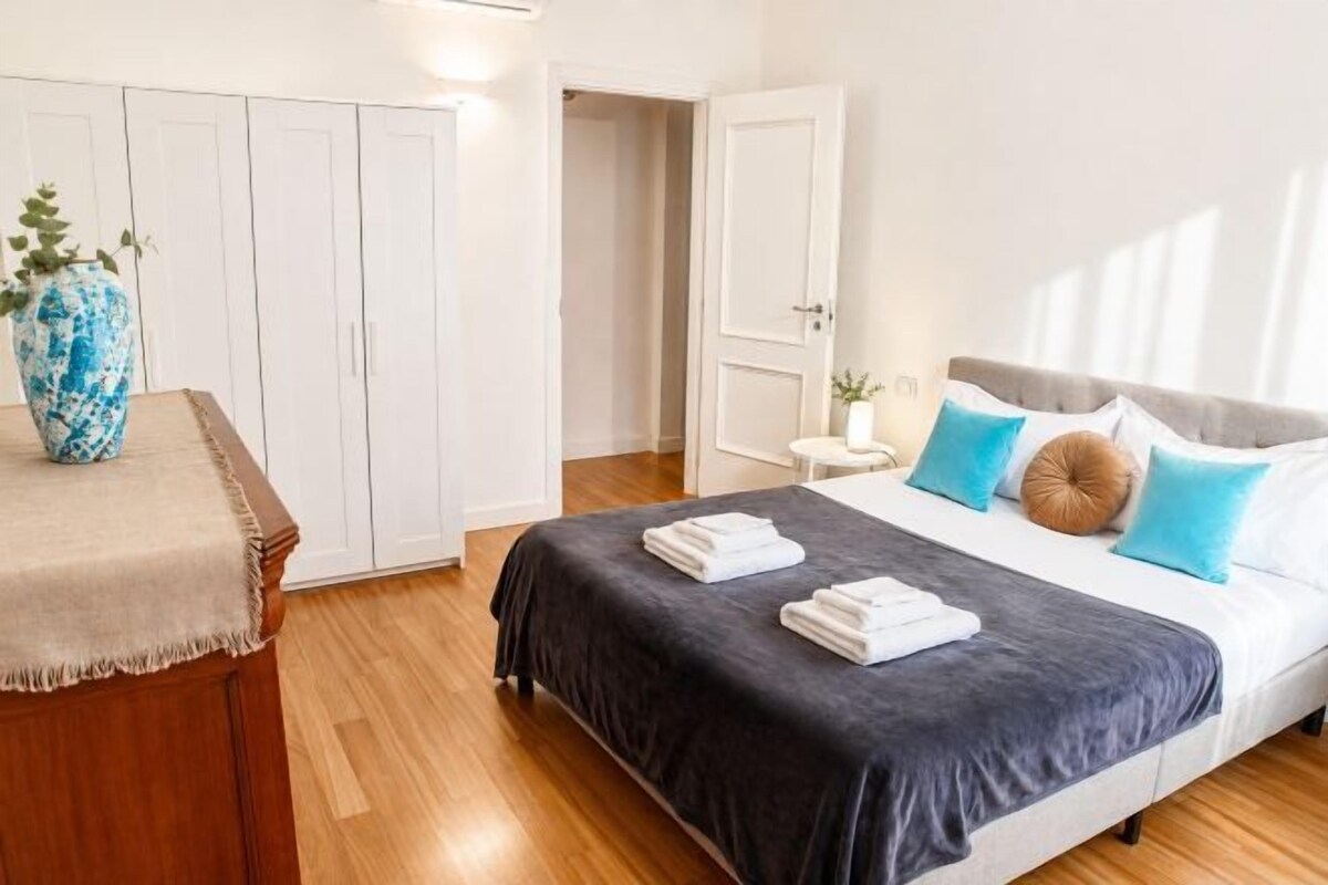 Un dormitorio con cama, armario y mesita de noche.