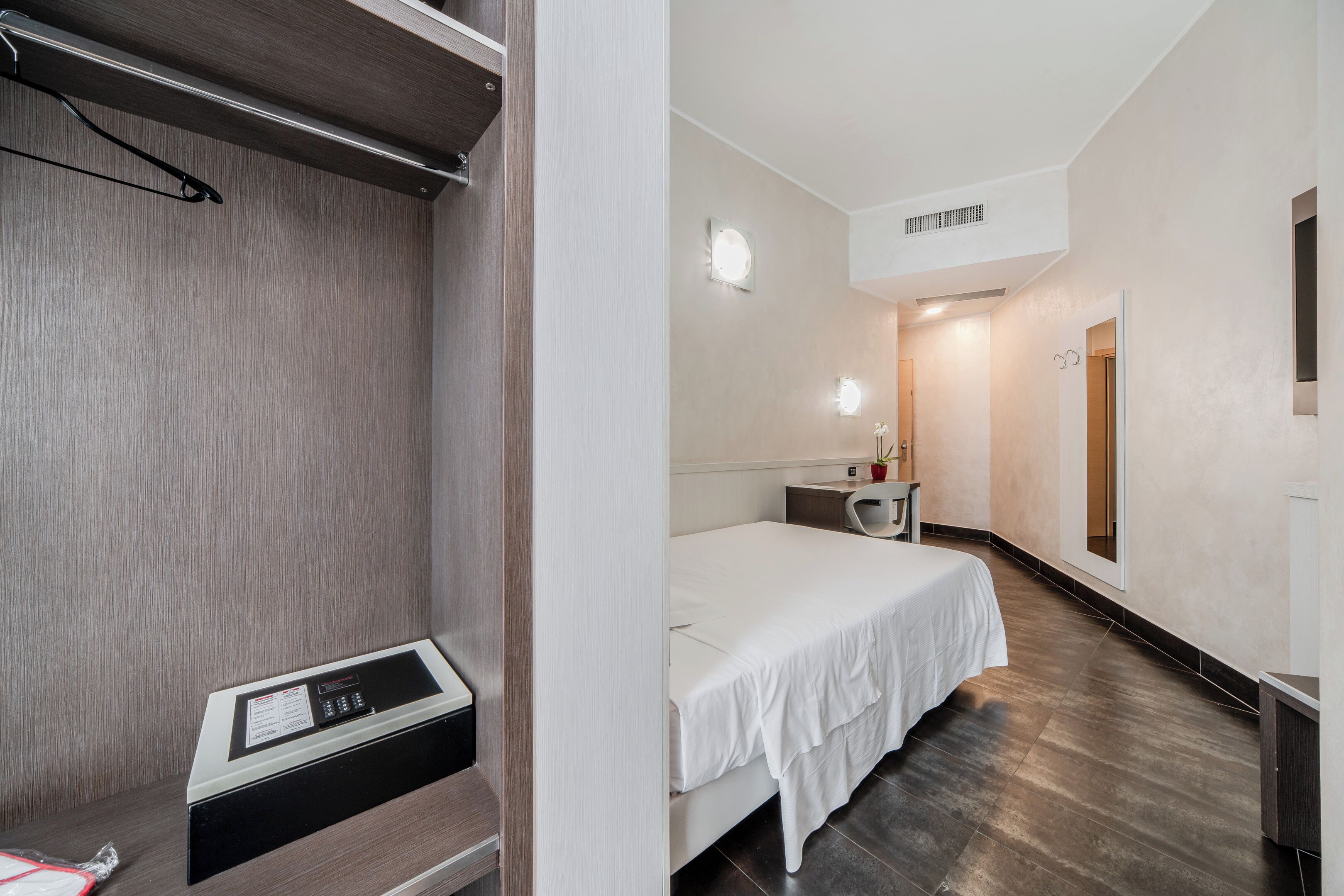 Ein Hotelzimmer mit Bett, Nachttisch und Bedienfeld.