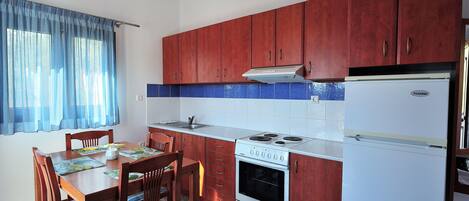 Una cocina con armarios de madera, una estufa blanca y un refrigerador.