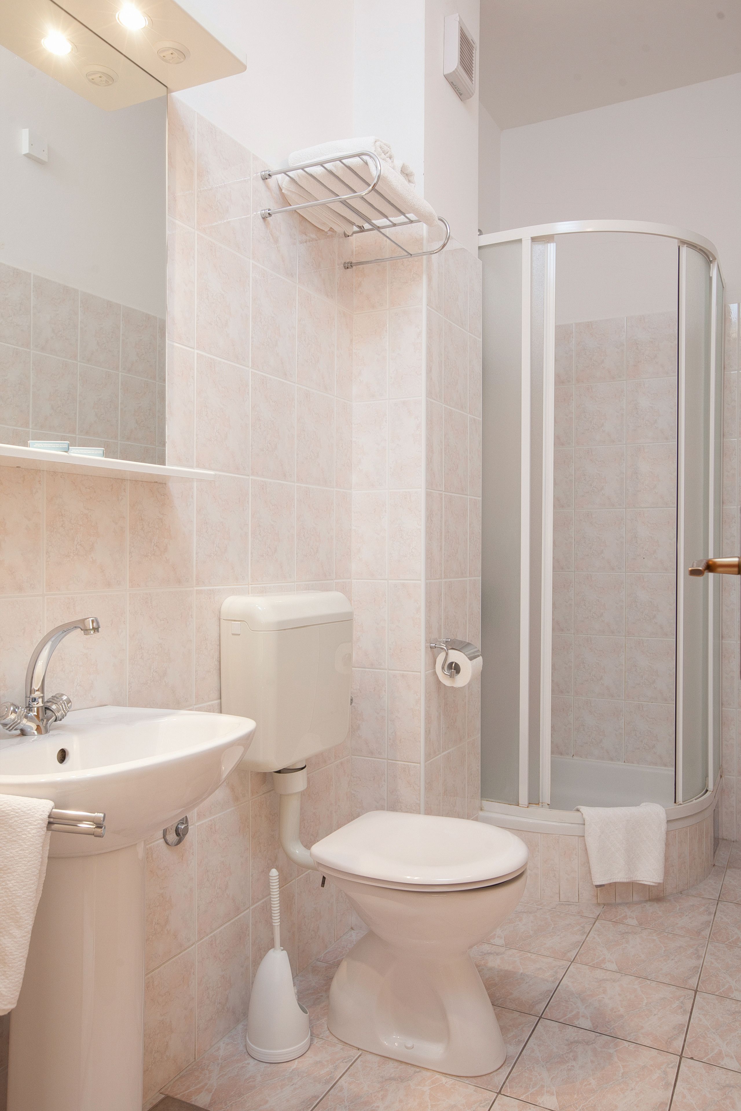 A modern bathroom with a sink, toilet, and glass-enclosed shower.