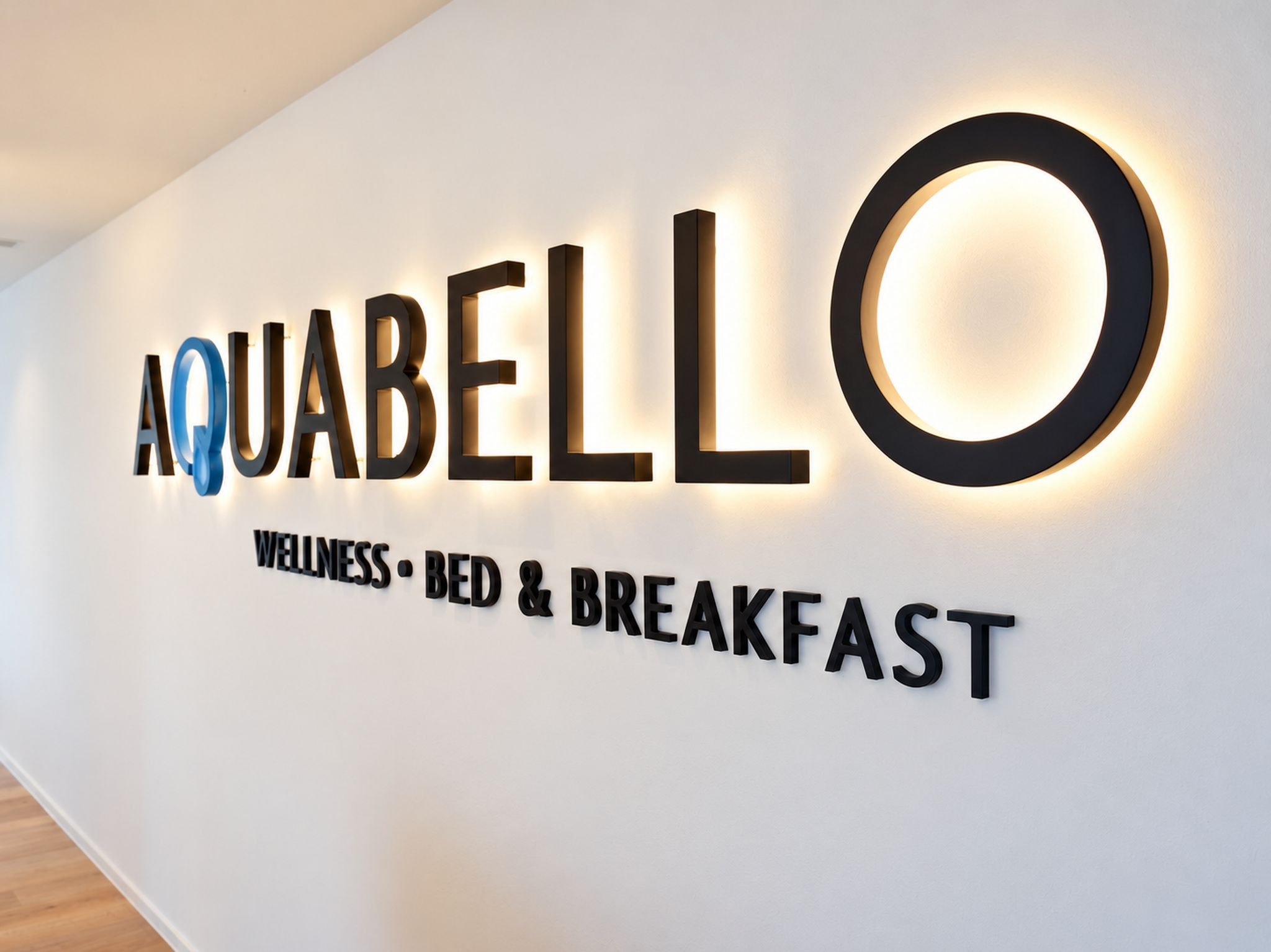 Un letrero en la pared con las palabras 'AQUABELLO' y 'WELLNESS BED & BREAKFAST', indicando un establecimiento enfocado en bienestar.