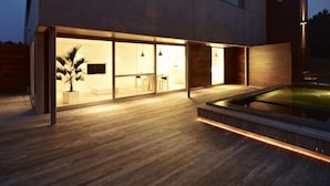 A modern house with large glass windows, a wooden deck, and a swimming pool. - Aquabello (Roeselare)