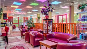 L’intérieur d’un restaurant avec des chaises en cuir rouge, une table en bois et un panneau lumineux au néon.
