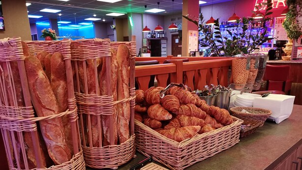 Une vitrine de boulangerie présentant des baguettes et des croissants.