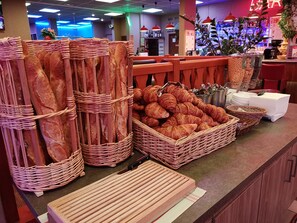 Een bakkerijdisplay met stokbroden en croissants.