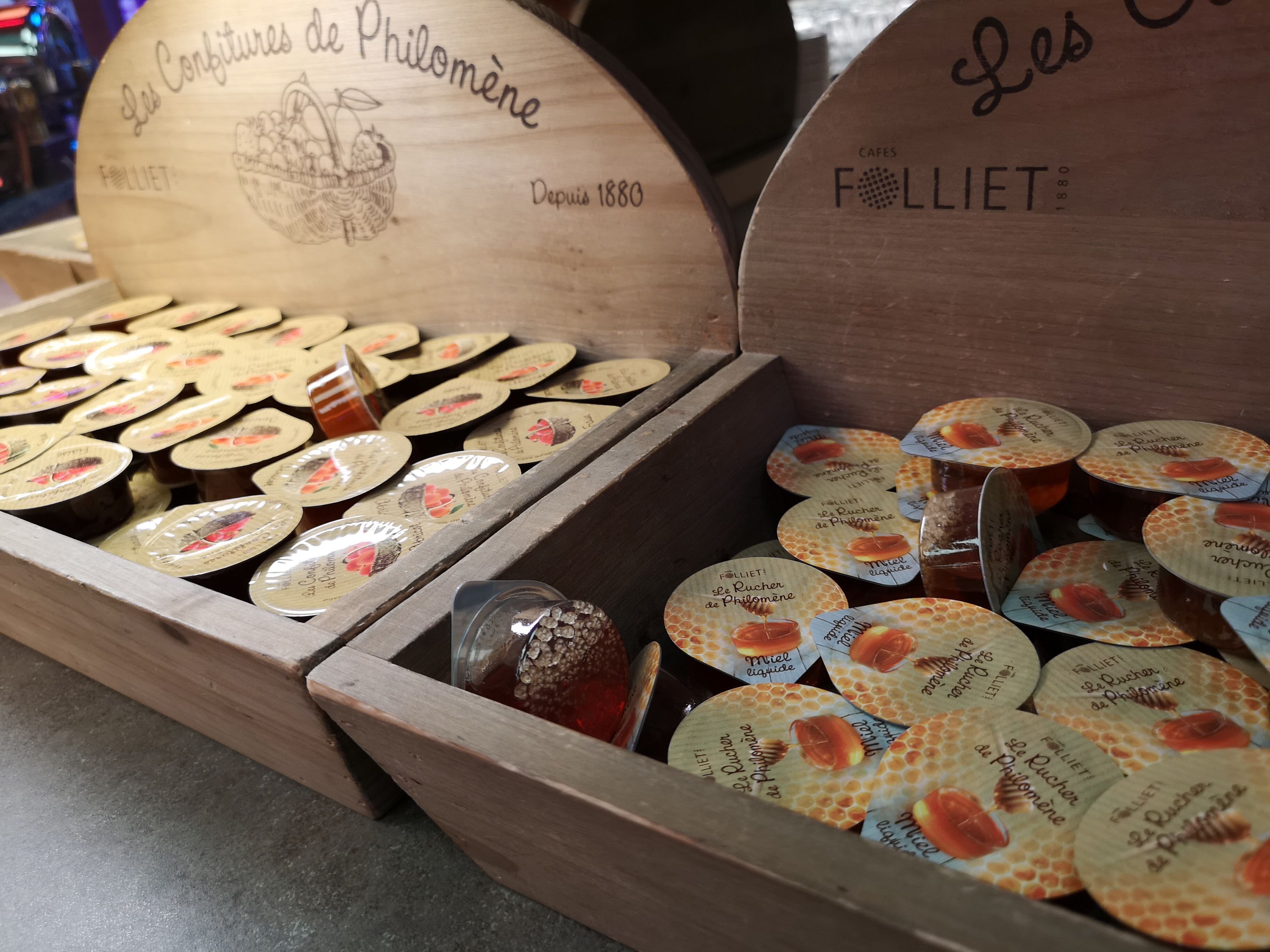 Une boîte en bois contenant des pots de miel et des étiquettes représentant des rayons de miel.
