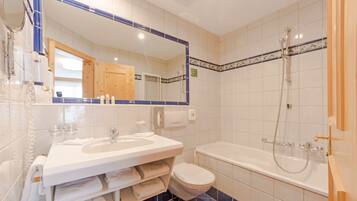 Un baño con lavamanos, inodoro y bañera.