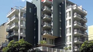 A multi-story building with balconies, large windows, and a clear sky. - BA Sohotel (Buenos Aires)