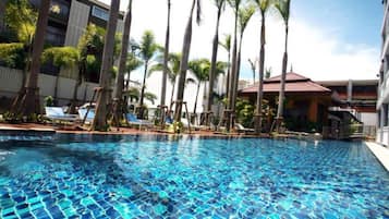 Una piscina al aire libre, sillones reclinables de piscina