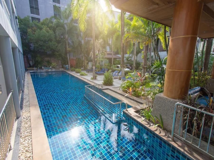 Una piscina al aire libre, sillones reclinables de piscina