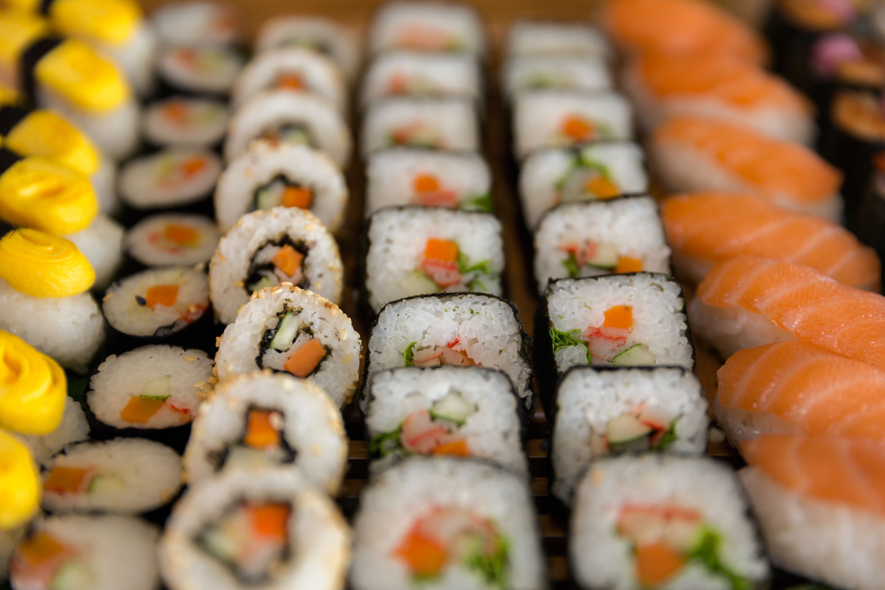 A variety of sushi rolls and nigiri arranged on a tray.