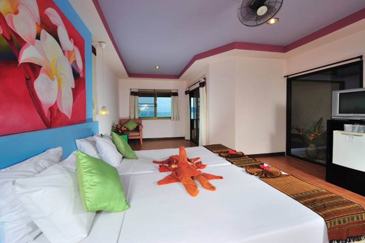 Une chambre d’hôtel avec un lit, une télévision, une grande fenêtre et une vue sur l’extérieur.
