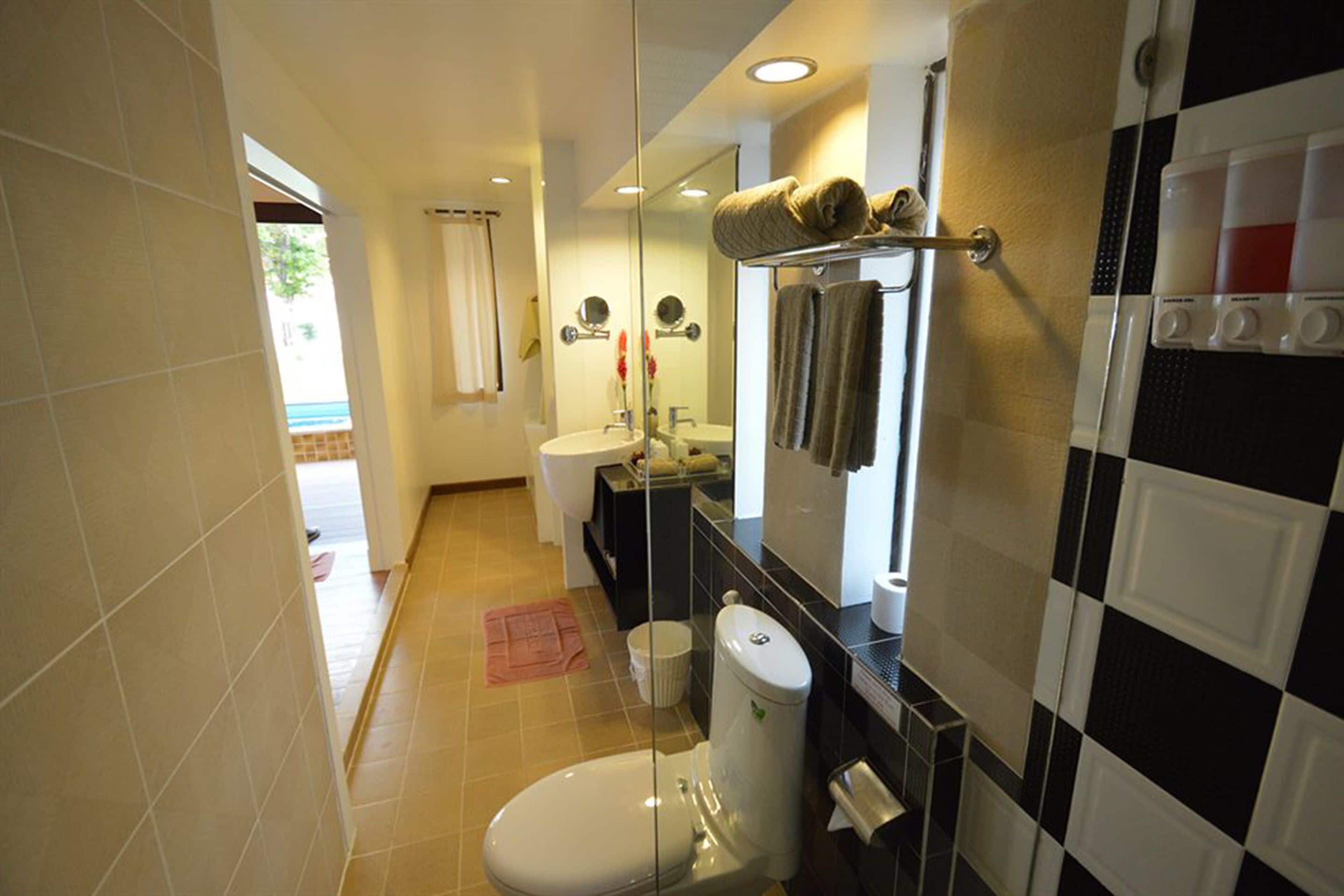 Un baño pequeño con inodoro, lavamanos y espejo.