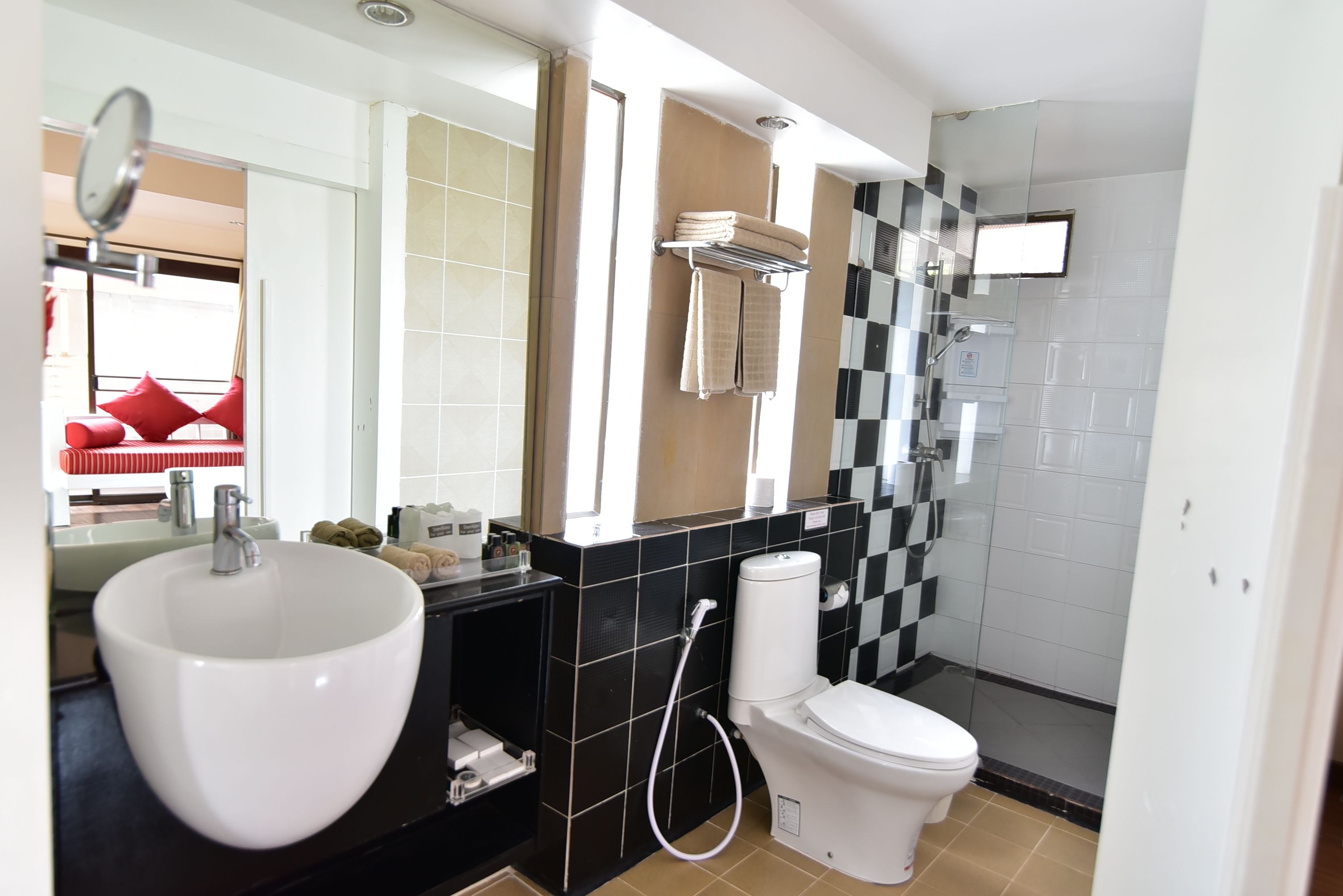 A modern bathroom with a large white sink, a toilet, and a glass shower enclosure.