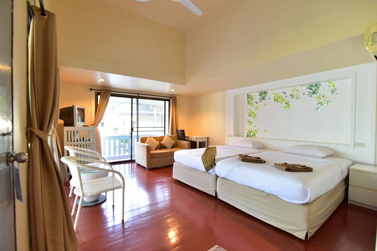 Ein Hotelzimmer mit Bett, Stuhl, Schreibtisch und Balkon.