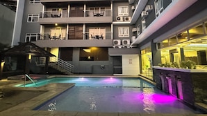 A multi-story hotel with a swimming pool, outdoor seating, and balconies. - Circle Inn - Iloilo City Center (Iloilo)