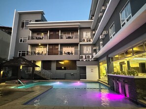 Una piscina al aire libre, sillones reclinables de piscina