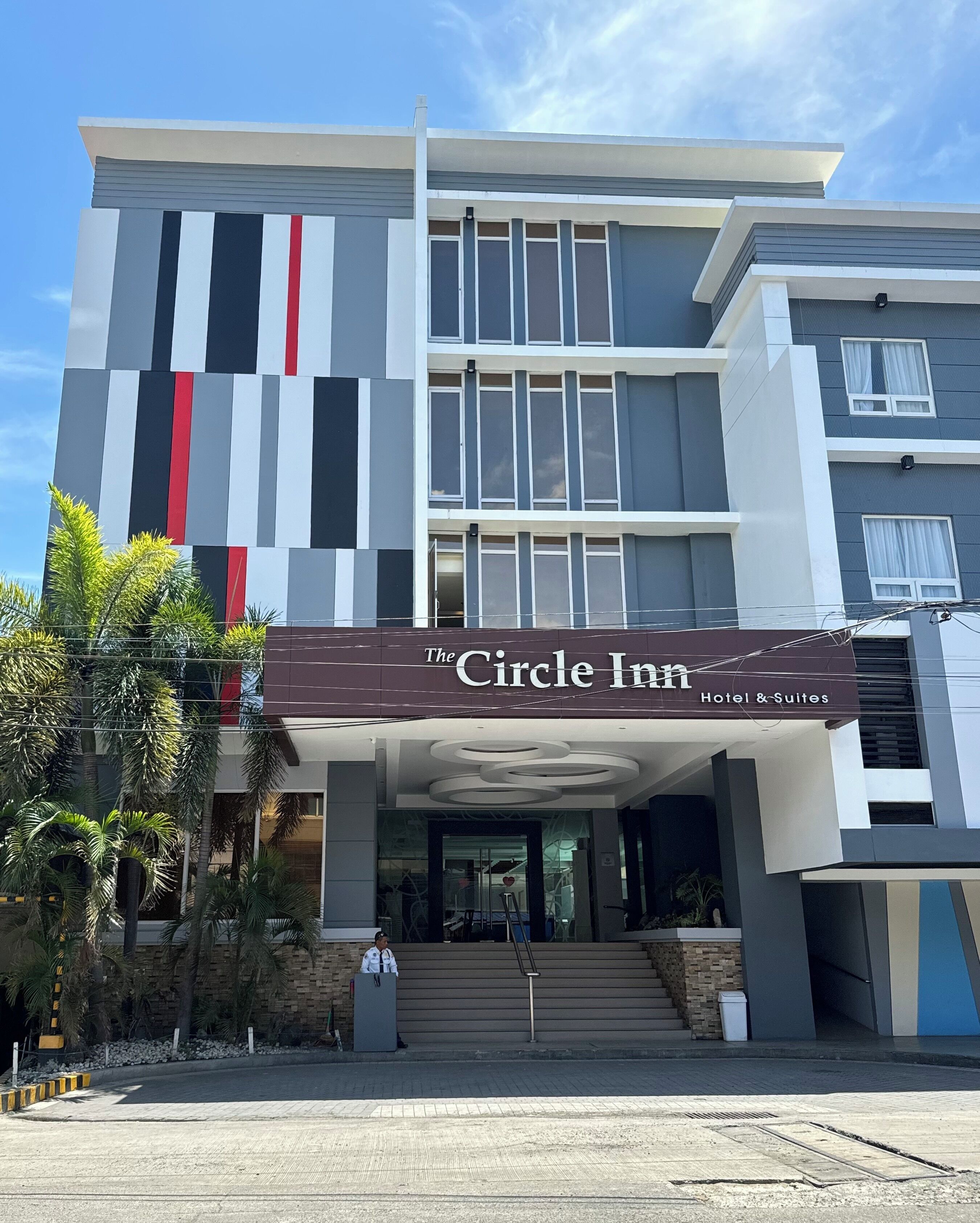 Un hotel moderno con un cartel llamativo que dice 'The Circle Inn Hotel & Suites'.