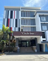 Un hotel moderno con un cartel llamativo que dice 'The Circle Inn Hotel & Suites'.