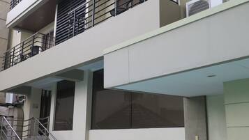 Un edificio de varios pisos con balcones, una escalera y una piscina.