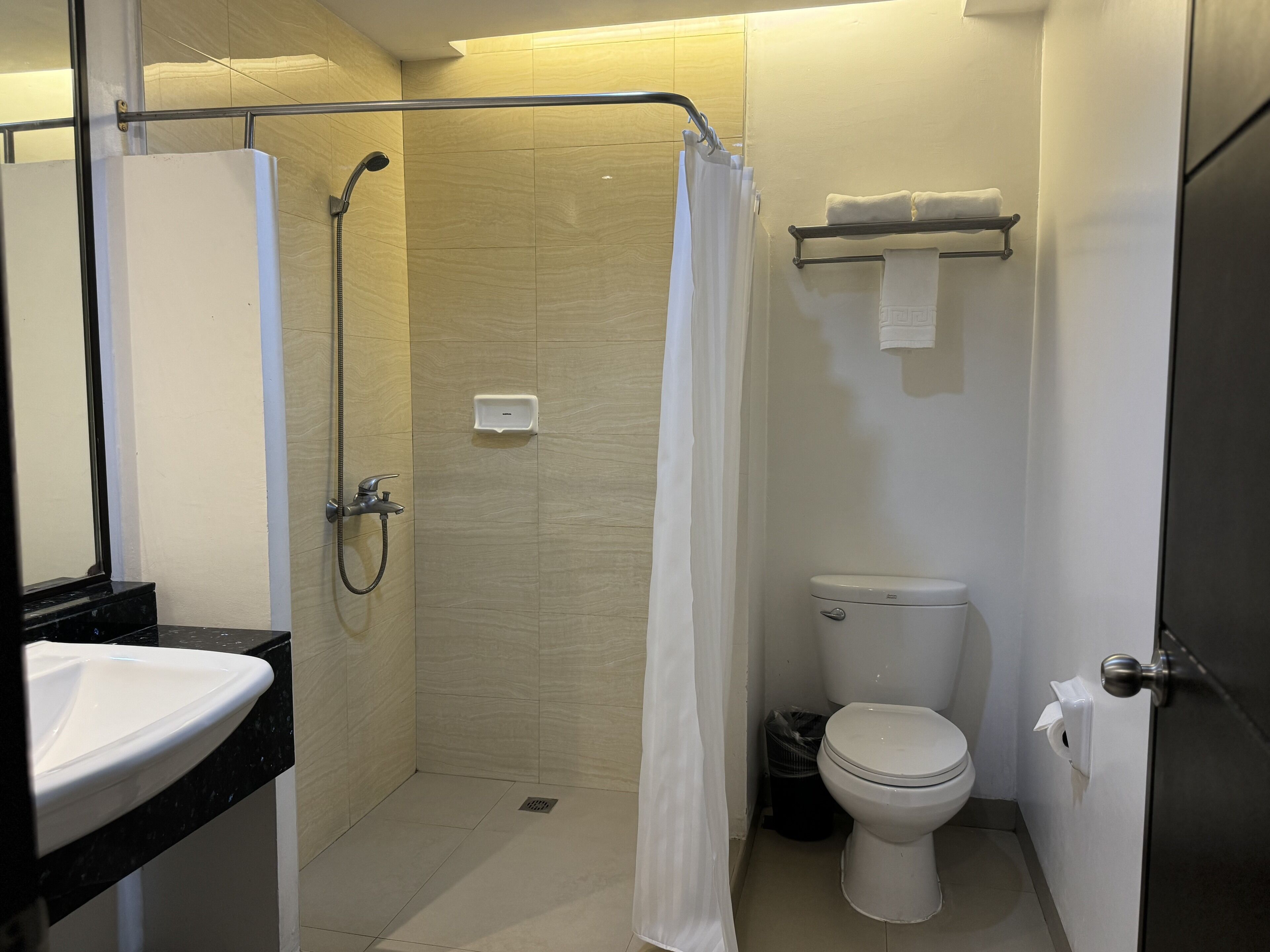 Un bagno con doccia, WC e lavandino.